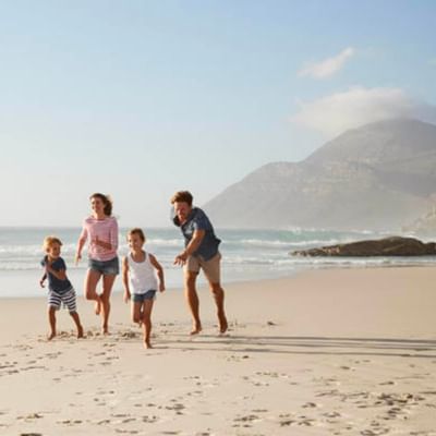 A family enjoying the sunny beach near The Originals Hotels