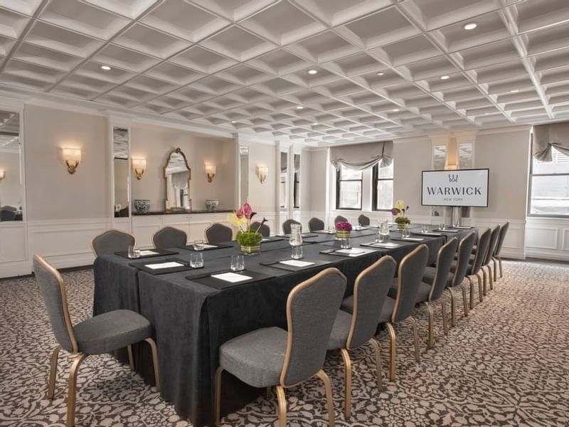 Boardroom table set up with a digital screen in Oxford meeting room at Warwick New York