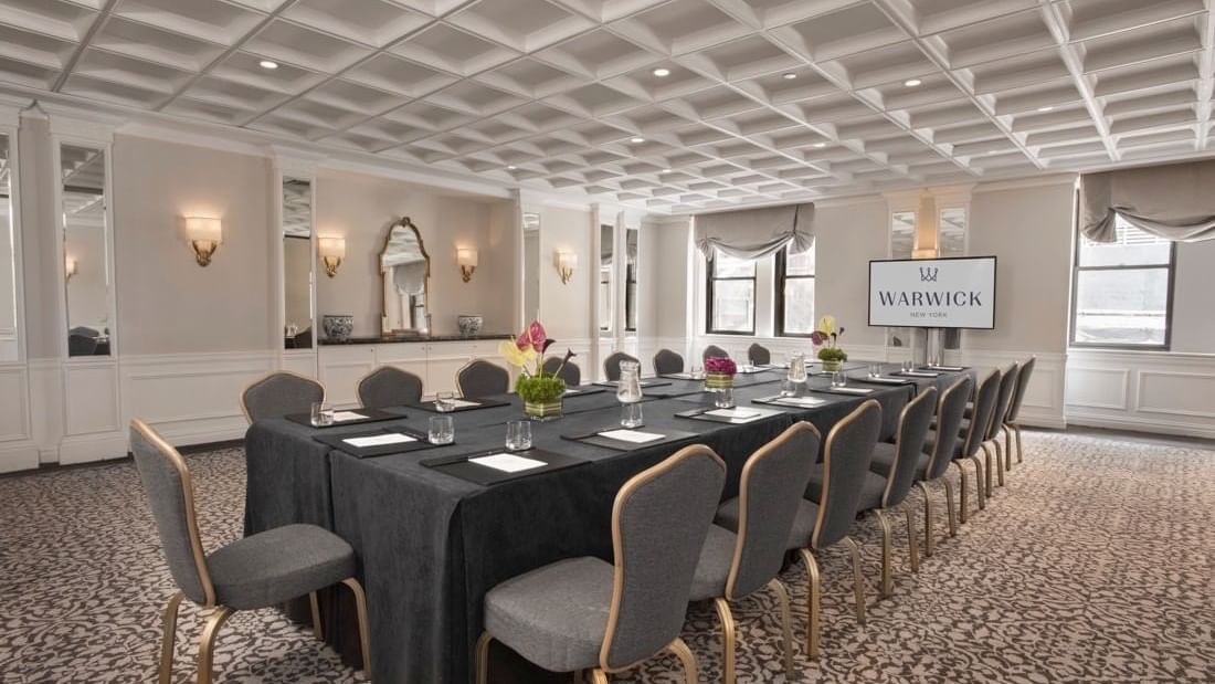 Boardroom table set up with a digital screen in Oxford meeting room at Warwick New York