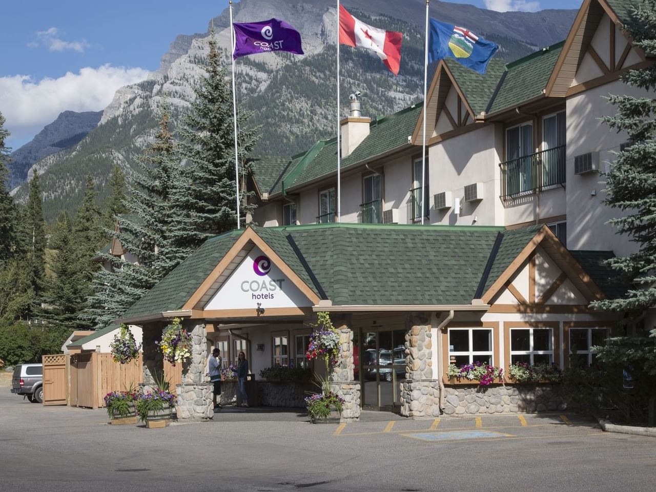 Exterior of Coast Canmore Hotel & Conference Centre surrounded by mountains
