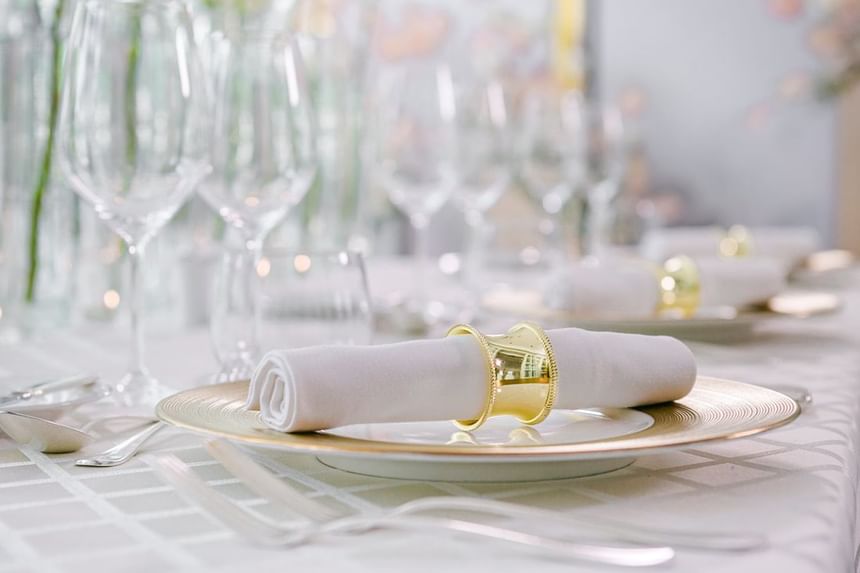 Dining table featuring elegant glassware, golden napkin holders for an event at Park Hyatt Saigon