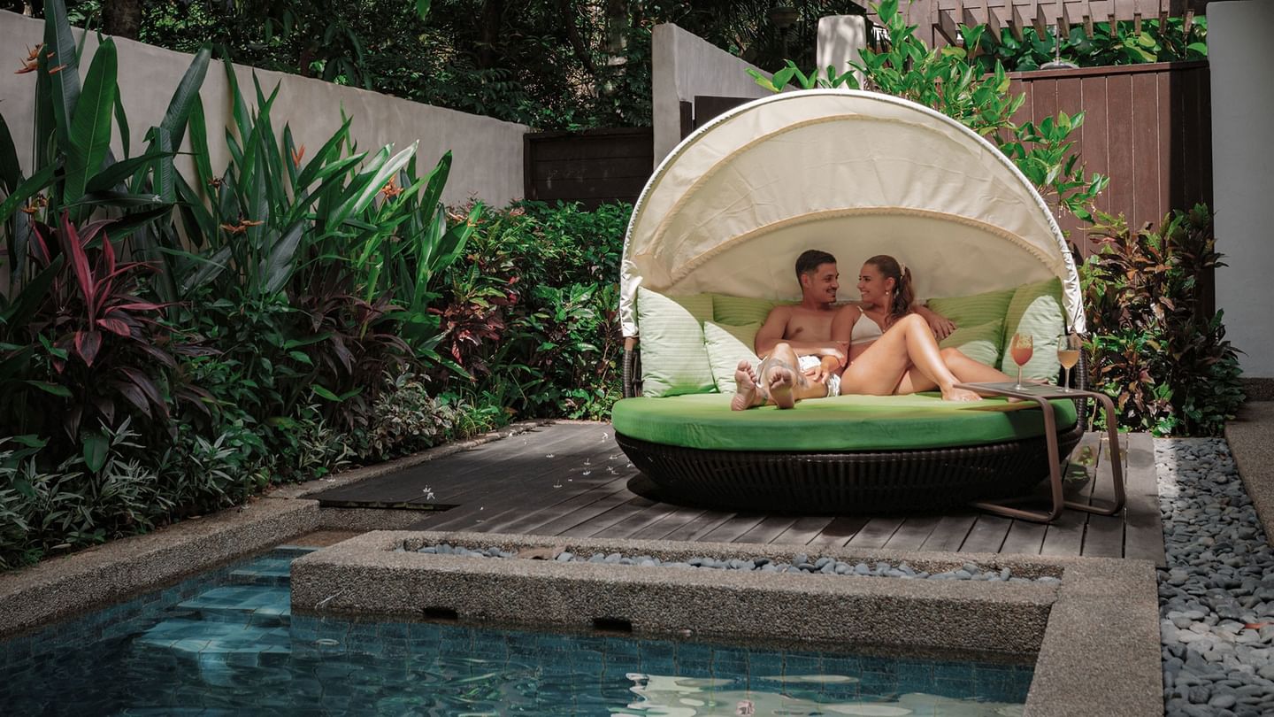 Couple relaxing on a sun bed by a pool for Valentine's Day stay package