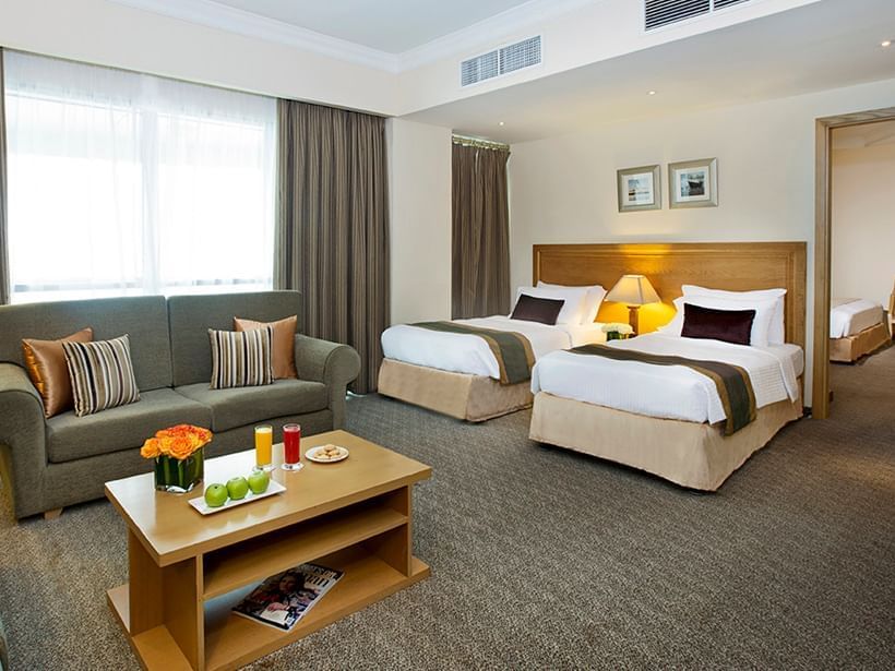 Twin beds and sofa in Family Suite at City Seasons Hotels