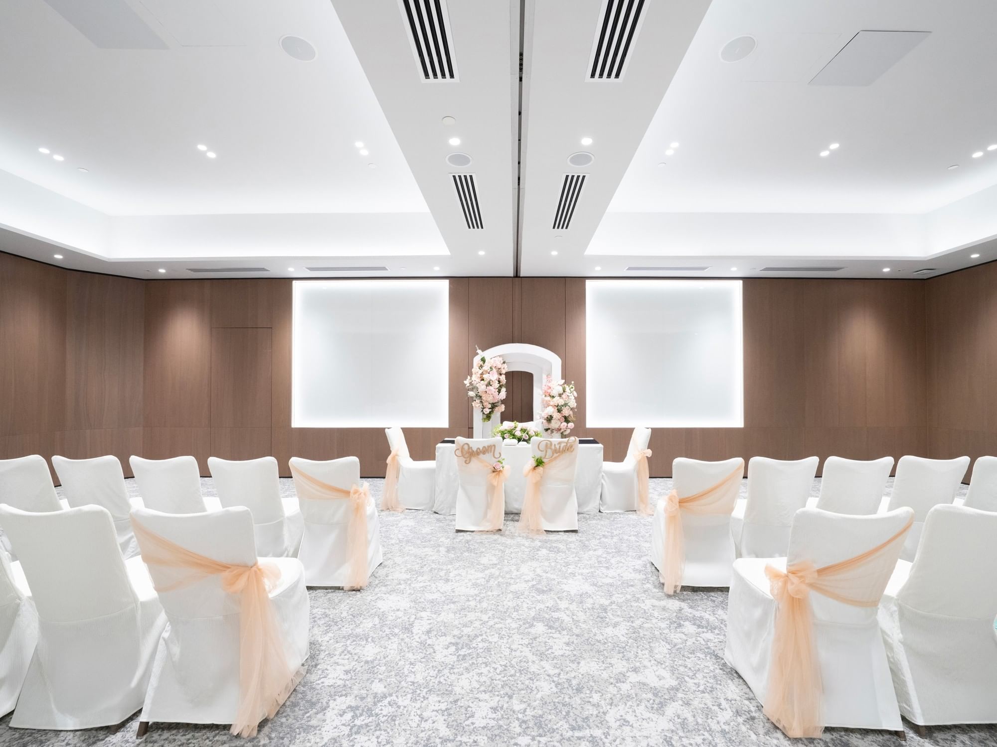 Solemnisation setup in a meeting room at Paradox Singapore, featuring an elegant arrangement with a decorated ceremonial table, chairs for guests, and tasteful floral accents in a bright, intimate setting.