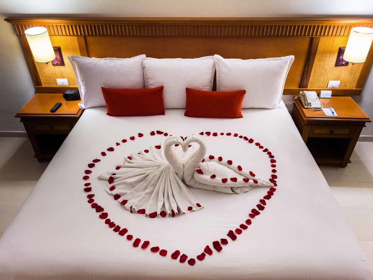 Bed with rose petals in Premium Room at The Reef Coco Beach
