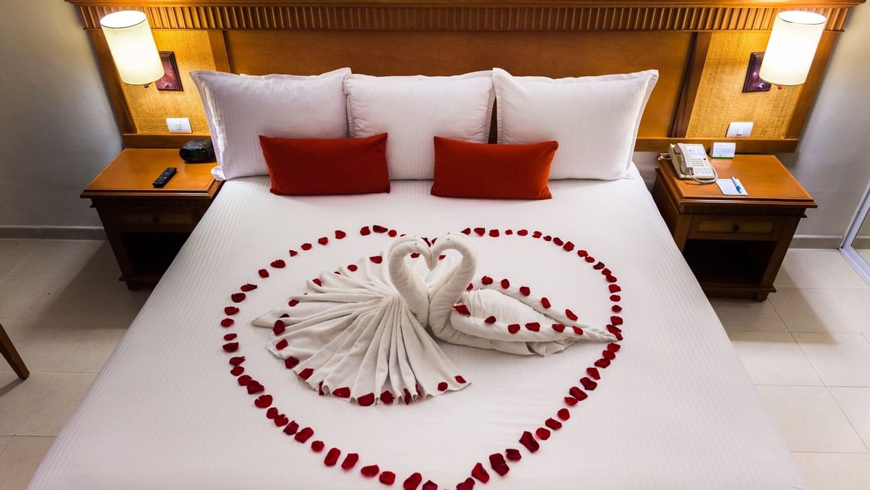 Bed with rose petals in Premium Room at The Reef Coco Beach
