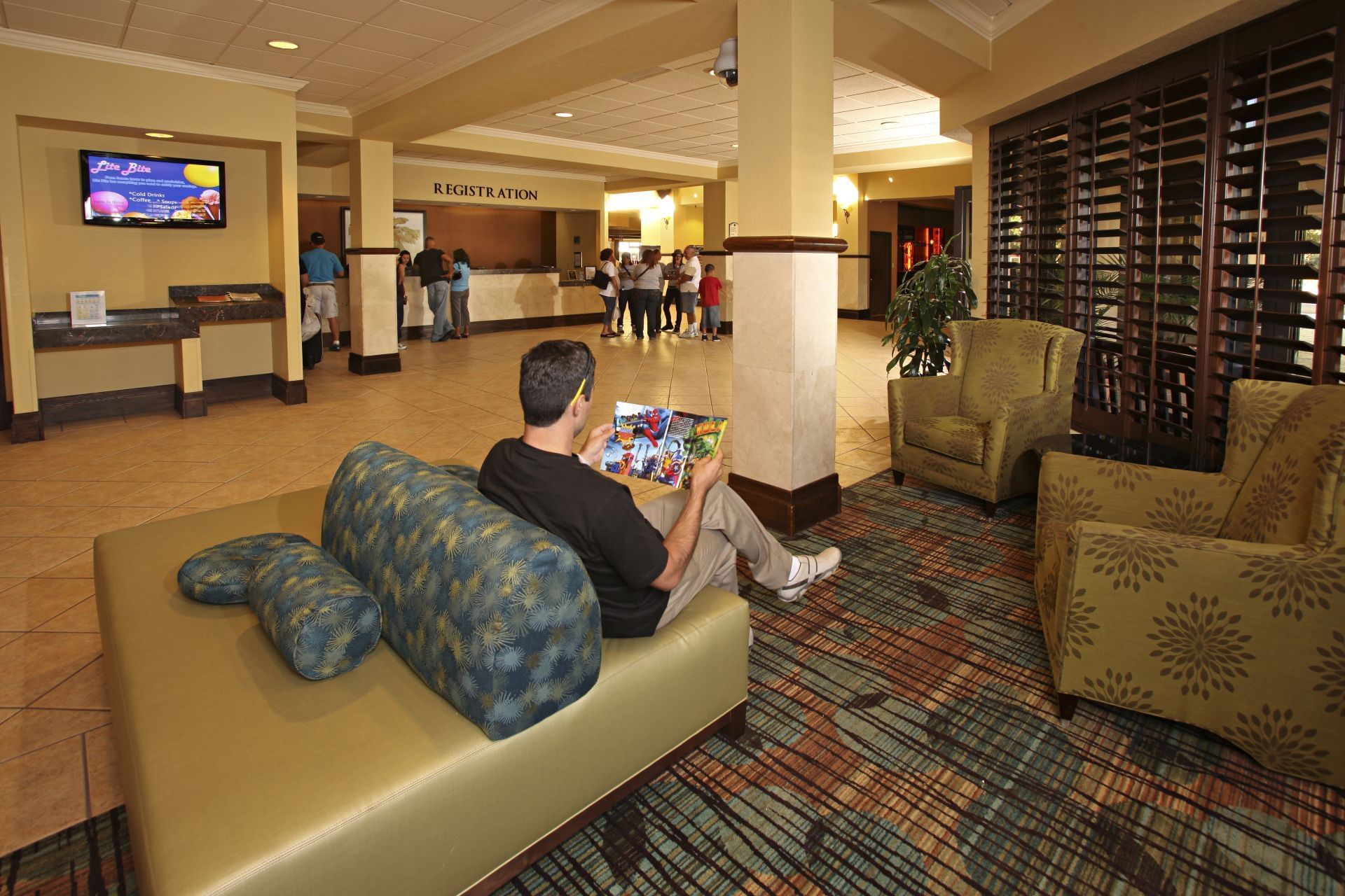 Man lounging in the lobby at Rosen Inn at Pointe Orlando