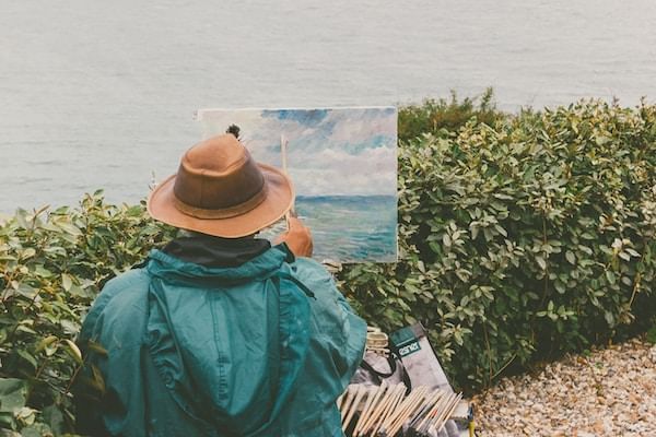 Man painting by Alta Lake near Blackcomb Springs Suites