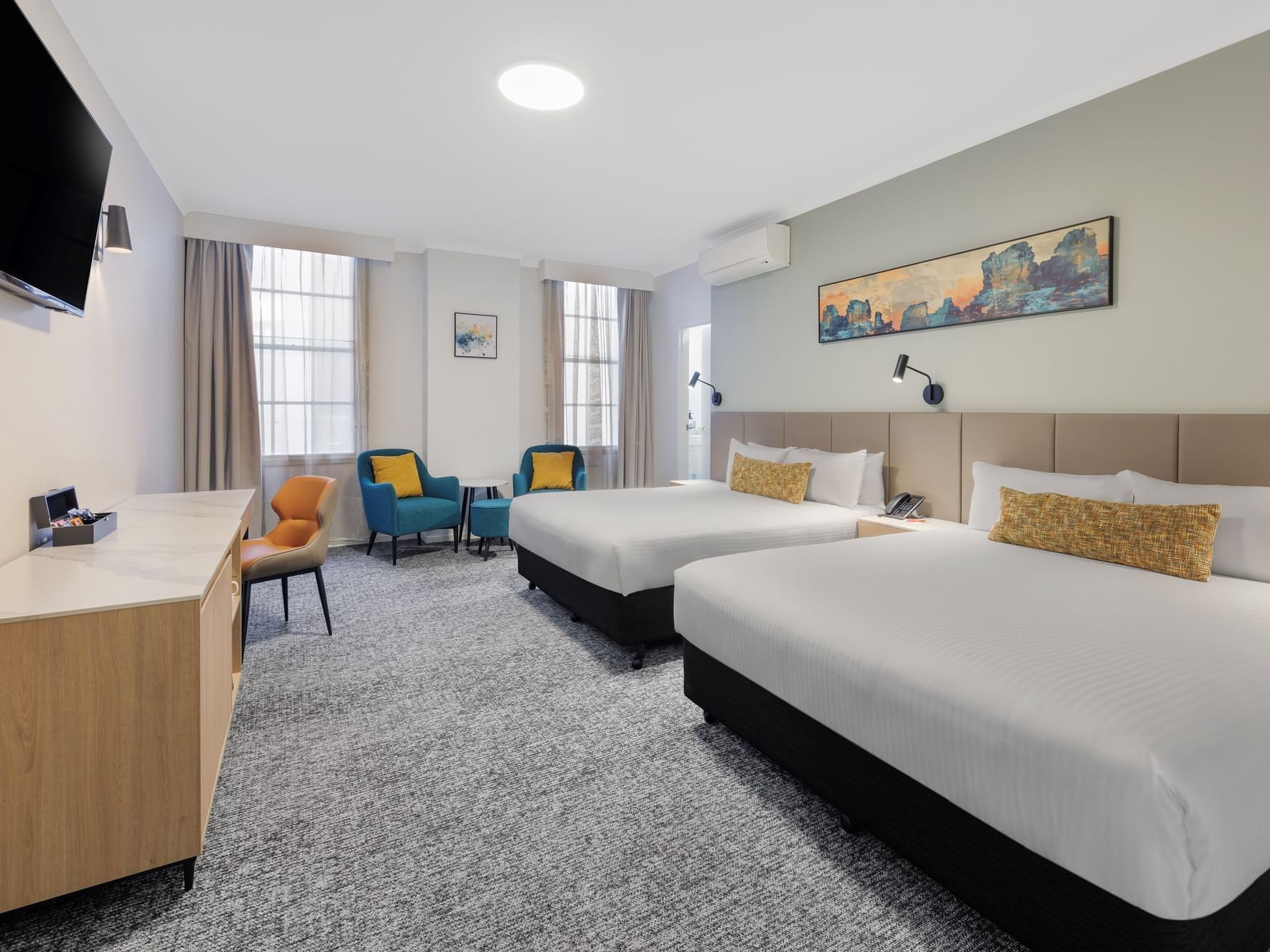 Twin beds, desk, and TV in a well-appointed hotel room.