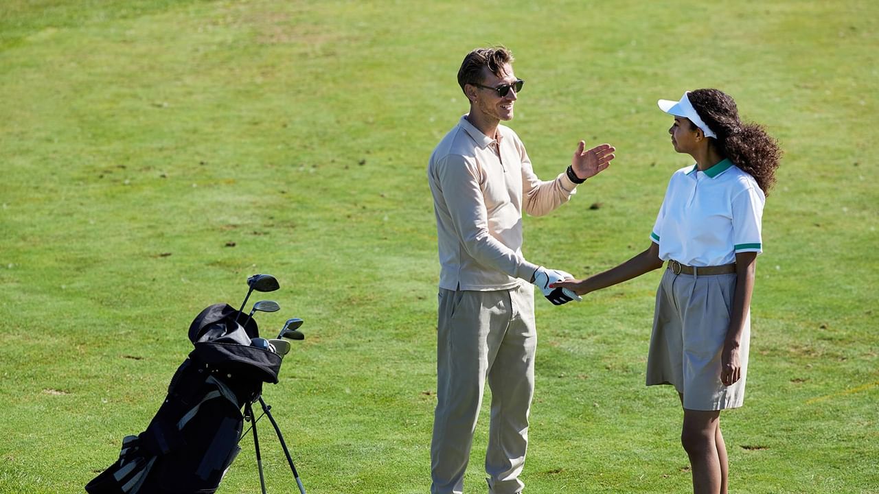 Two golfers shaking hands at a golf course