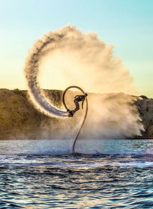 Homme faisant un flyboard sur l'eau avec un jet d'eau autour de lui à Ibiza Gran Hotel Custom