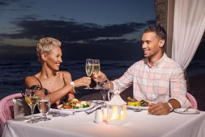 couple toasting at dinner by the sea at Sugar Bay Barbados