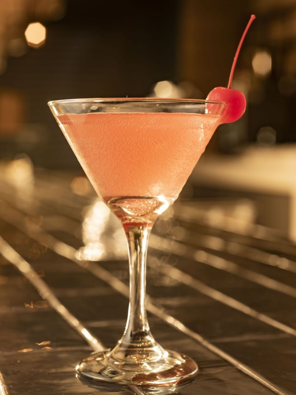 Close-up of a pink cocktail, garnished with a cherry in Bar 21 at El Conquistador Resort