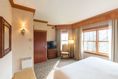 King Room at Lake Placid Club Grandview featuring wood trim, large windows, and a comfortable armchair by the corner