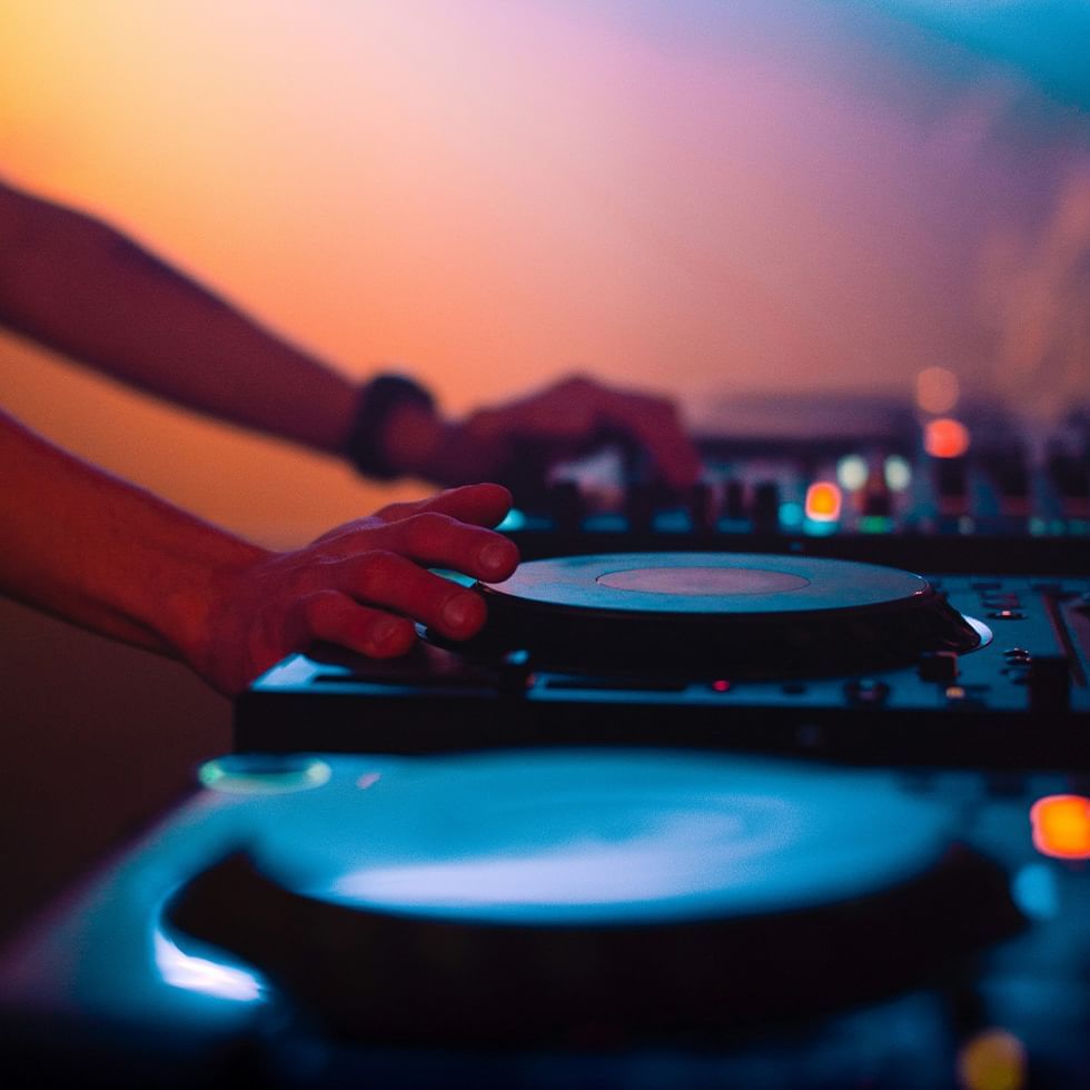 Close-up of a DJ's hands mixing music on a turntable at Falkensteiner Hotel Schladming