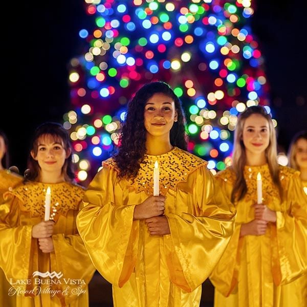 Ladies with candles in hand at EPCOT International Festival near Lake Buena Vista Resort Village & Spa