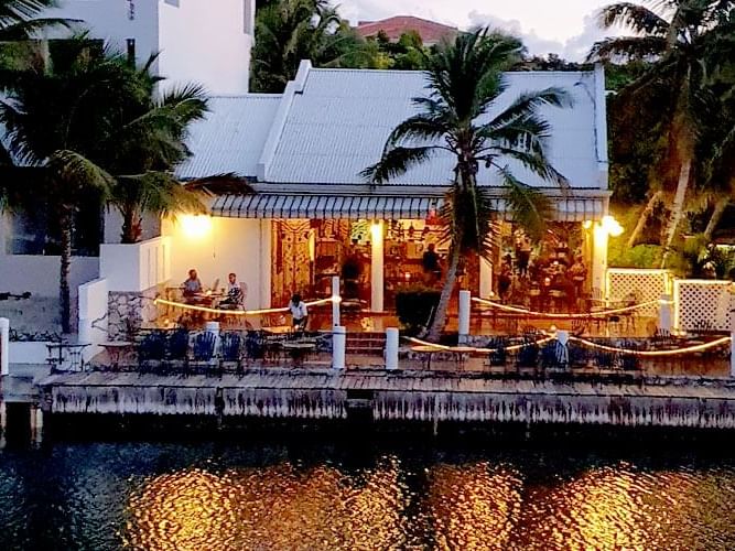 People dining on a deck in the Baci Italian Restaurant at Zenza Hotel