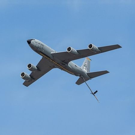 Large gray military aircraft flying in a clear blue sky, captured from Spencer Hotel & Conference Centre