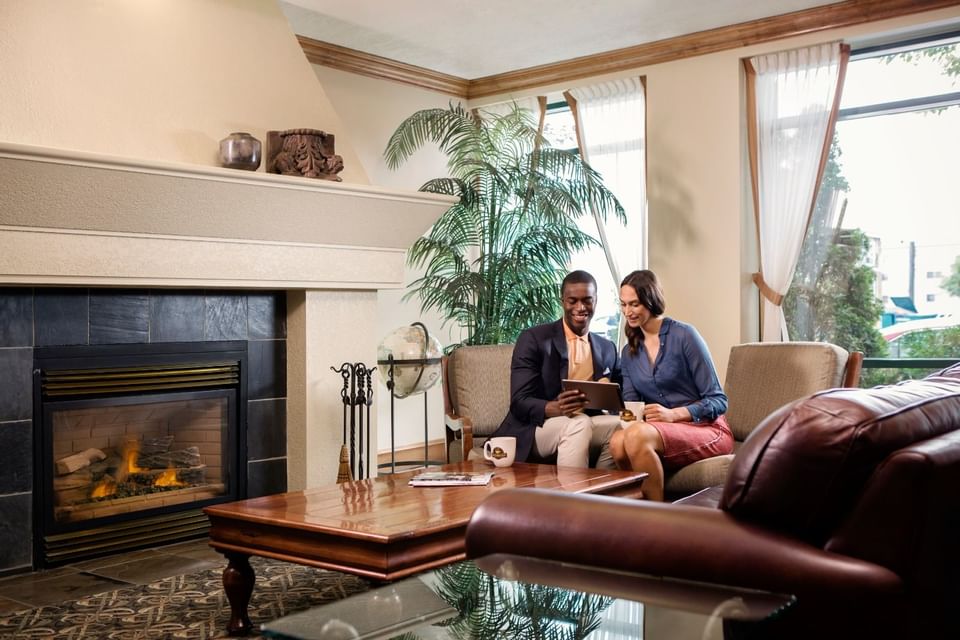 Couple discussing plans by the fireplace in the lobby at Varscona Hotel on Whyte