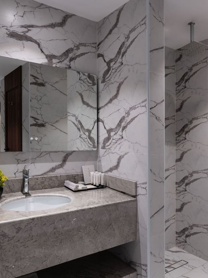 Deluxe Room bathroom featuring a marble vanity & a shower rack at Warwick Al Taif Hotel