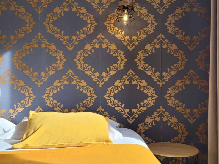 A bed with pillows & night light in a room at Originals Hotels