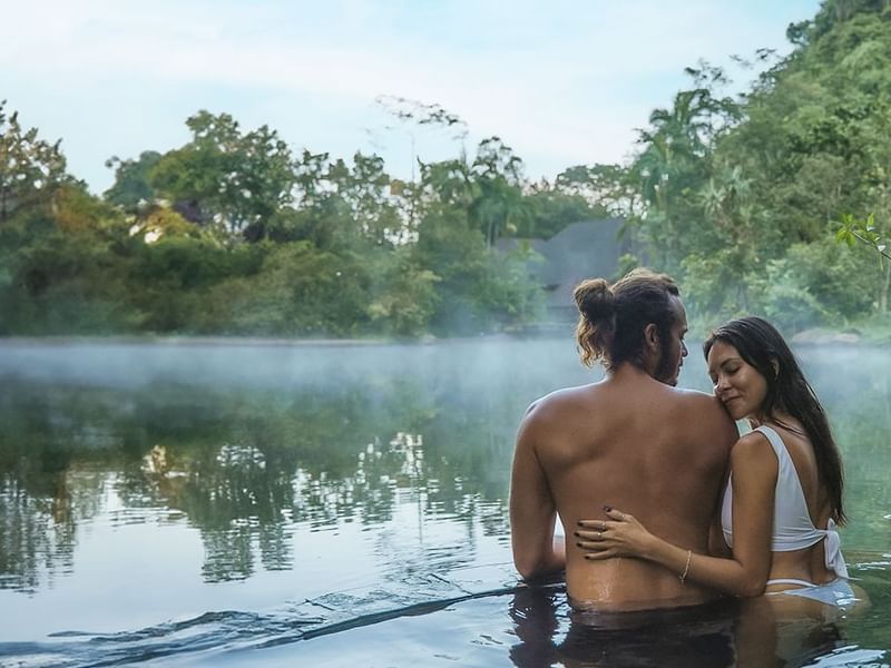Couple enjoying a swim at the lake with Banjaran's Day pass package at The Banjaran Hotsprings Retreat