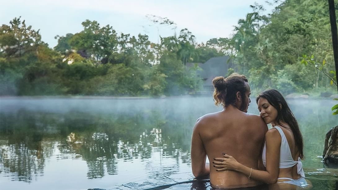 Couple enjoying a swim at the lake with Banjaran's Day pass package at The Banjaran Hotsprings Retreat