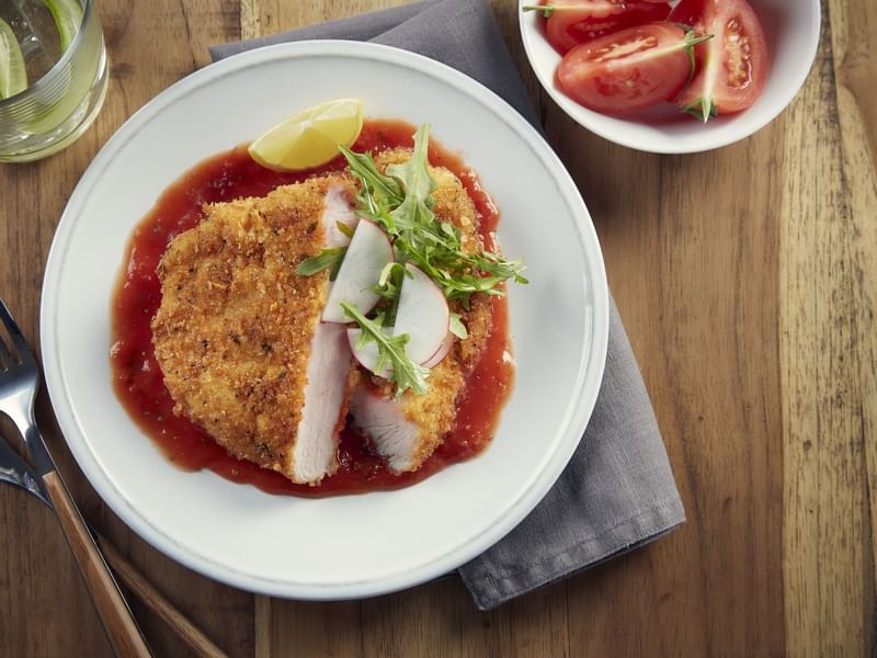 Breaded chicken schnitzel with lemon and tomato sauce in Restaurante La Distral at Grand Fiesta Americana