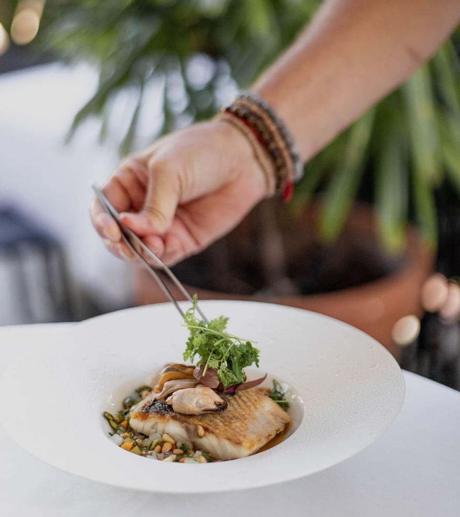 Closeup of a chef decorating a dish at Brazilian Court 