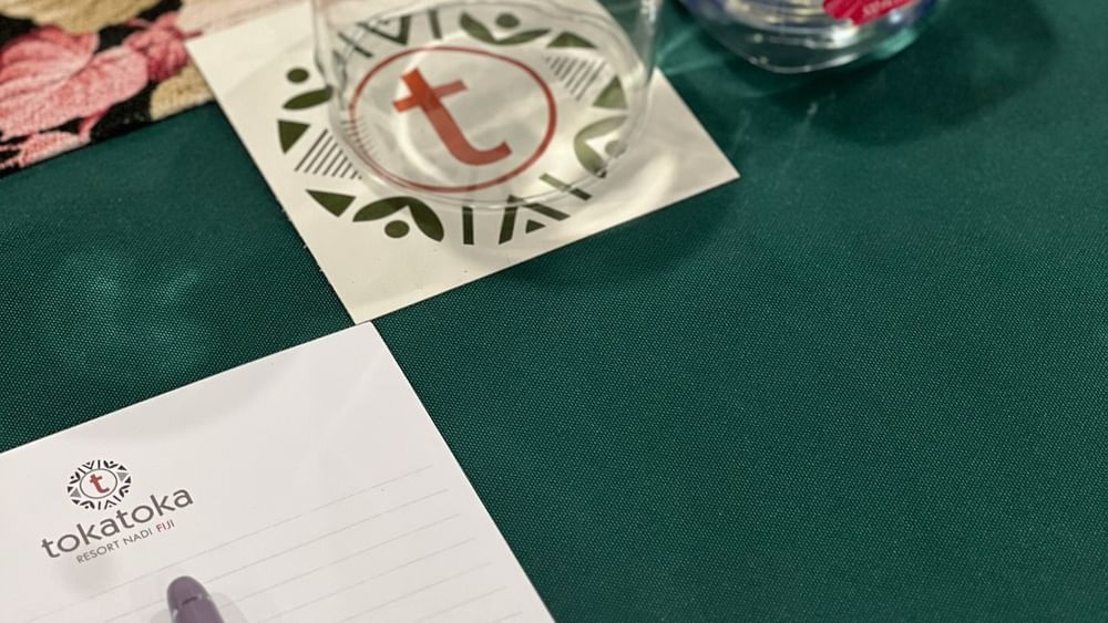 Tokatoka note paper, pen, wine glass, and water bottle at Talei Meeting Room in Nadi at Tokatoka Resort - Fiji International Airport.
