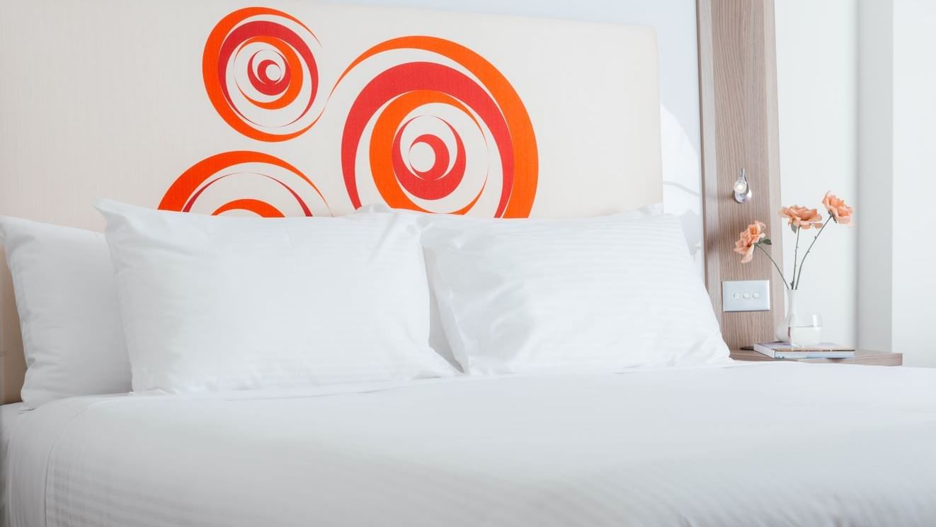 King-size bed with pillows in a room at Novotel Glen Waverley