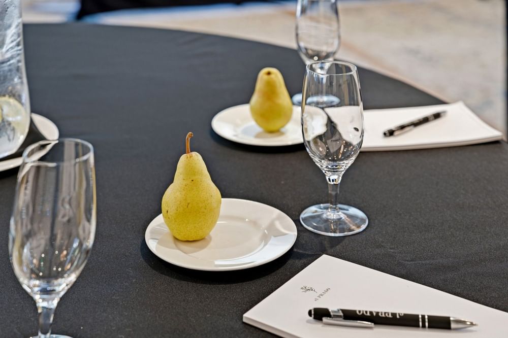 close up of meeting collateral featuring the el PRADO logo, and a yellow green pear on a white plate