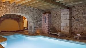 Wooden sunbeds by the indoor pool at Manoir des Indes