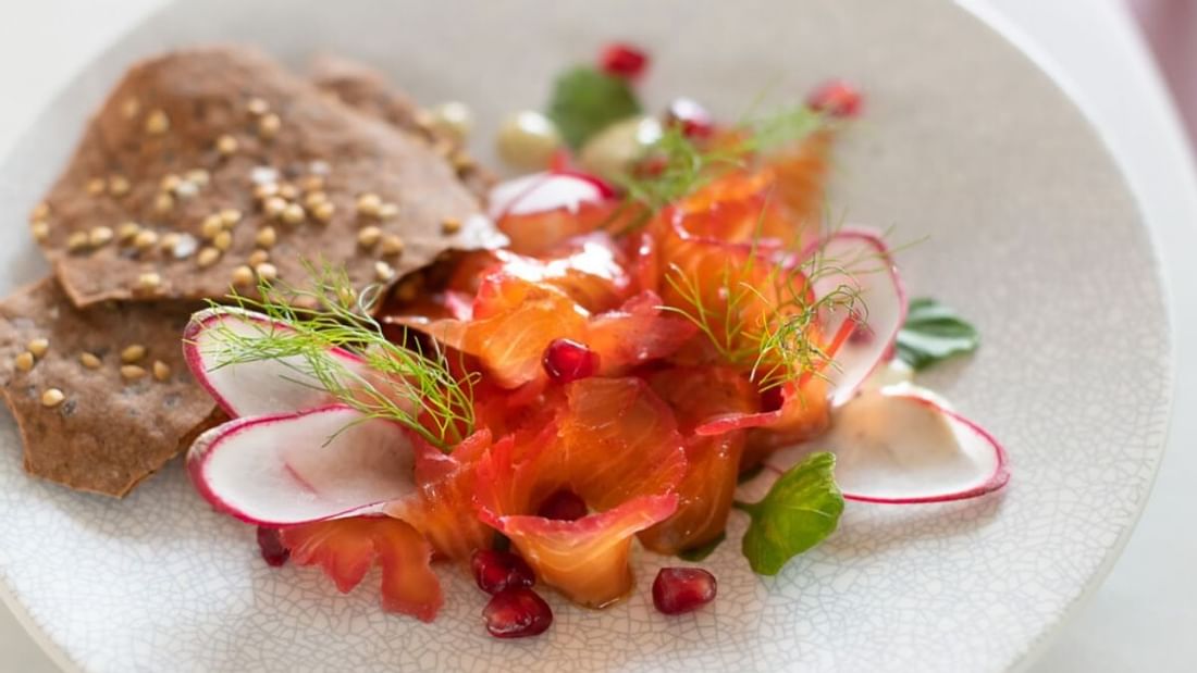 Smoked salmon with radish, pomegranate, and crackers served in The Marke Kitchen at Novotel Sydney International Airport