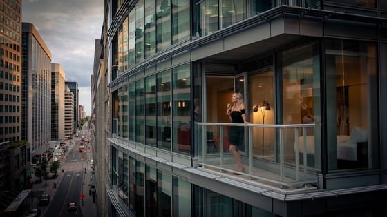 A woman drinking wine on the balcony at ReStays Ottawa