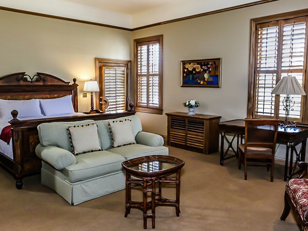 a couch, bed, and desk in a hotel room