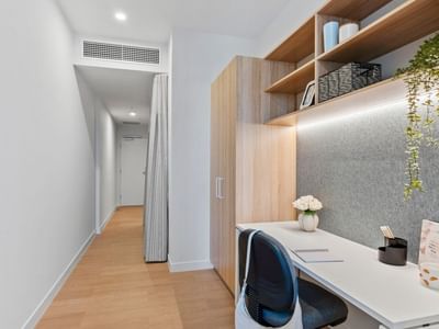 Modern office setup with desk, chair, and shelving at UniLodge Brisbane City.
