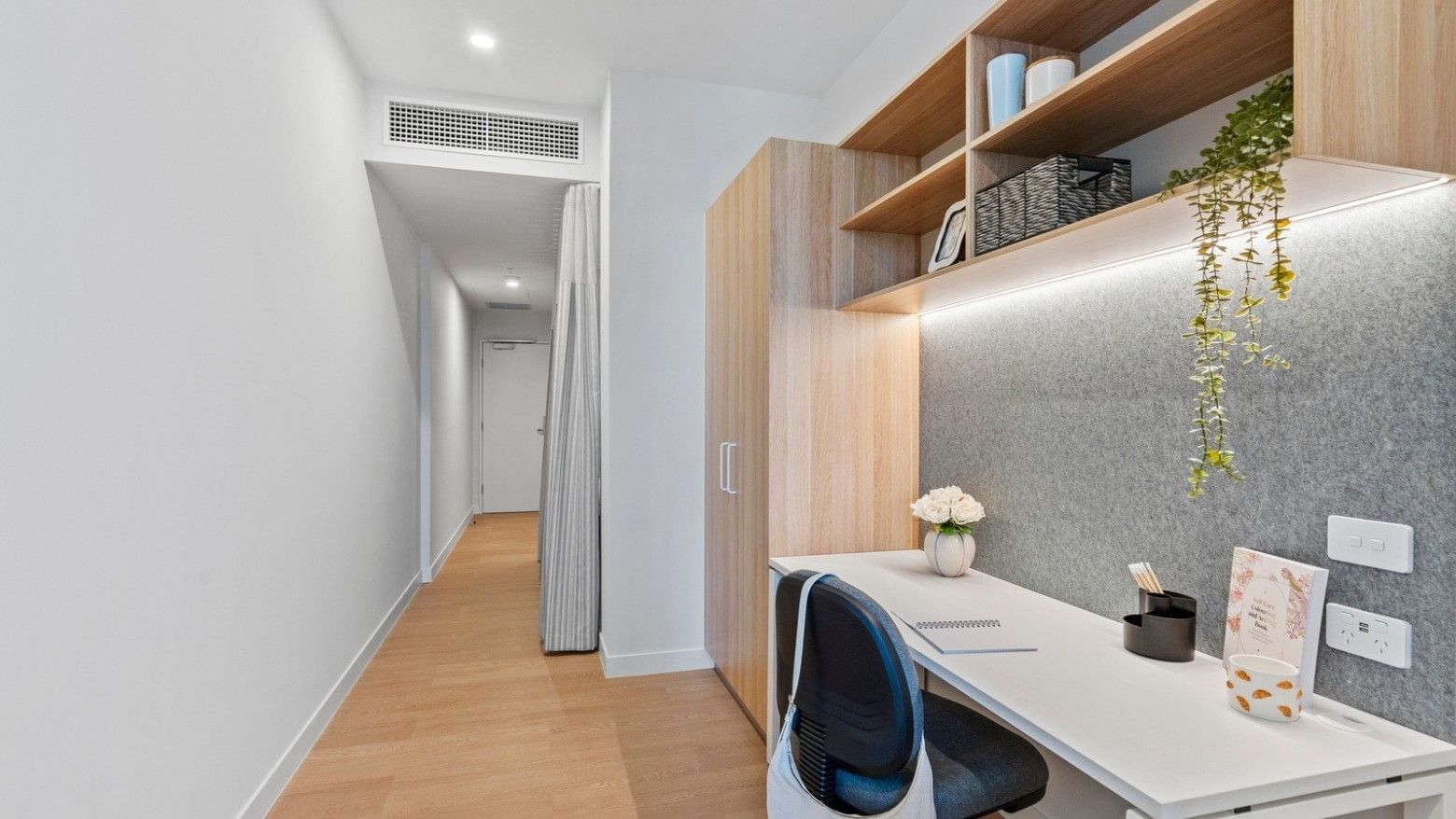 Modern office setup with desk, chair, and shelving at UniLodge Brisbane City.