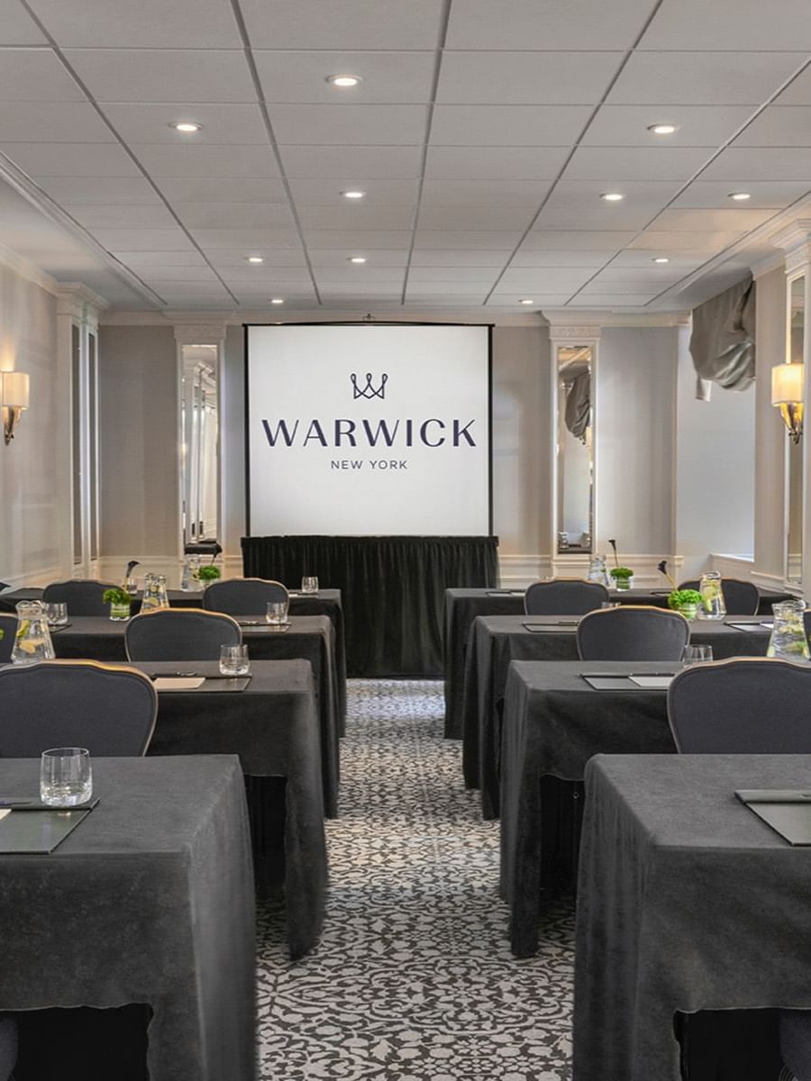 Classroom table set-up facing large screen in Sussex Meeting Room at Warwick New York