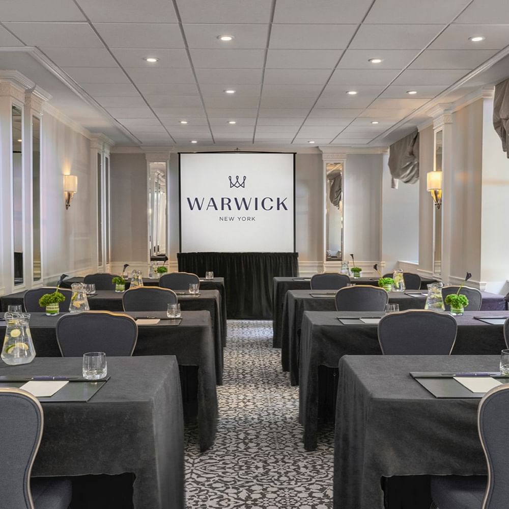 Classroom table set-up facing large screen in Sussex Meeting Room at Warwick New York