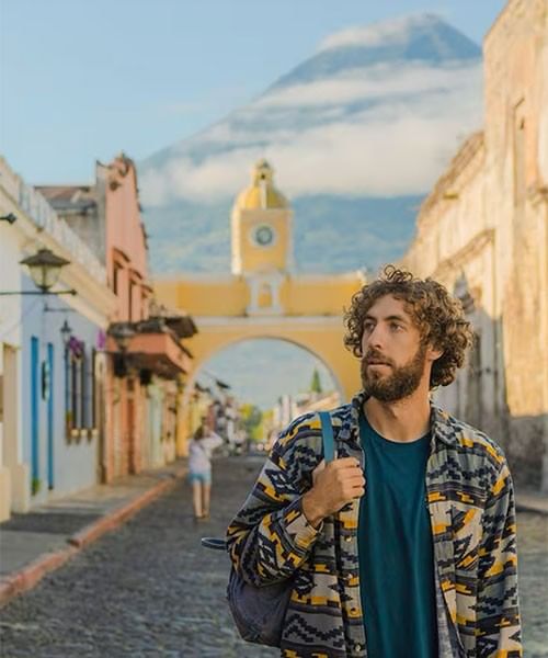 Hombre en la Calle Santa Catalina junto a paredes, con un volcán y una torre de reloj amarilla cerca de Porta Hotels