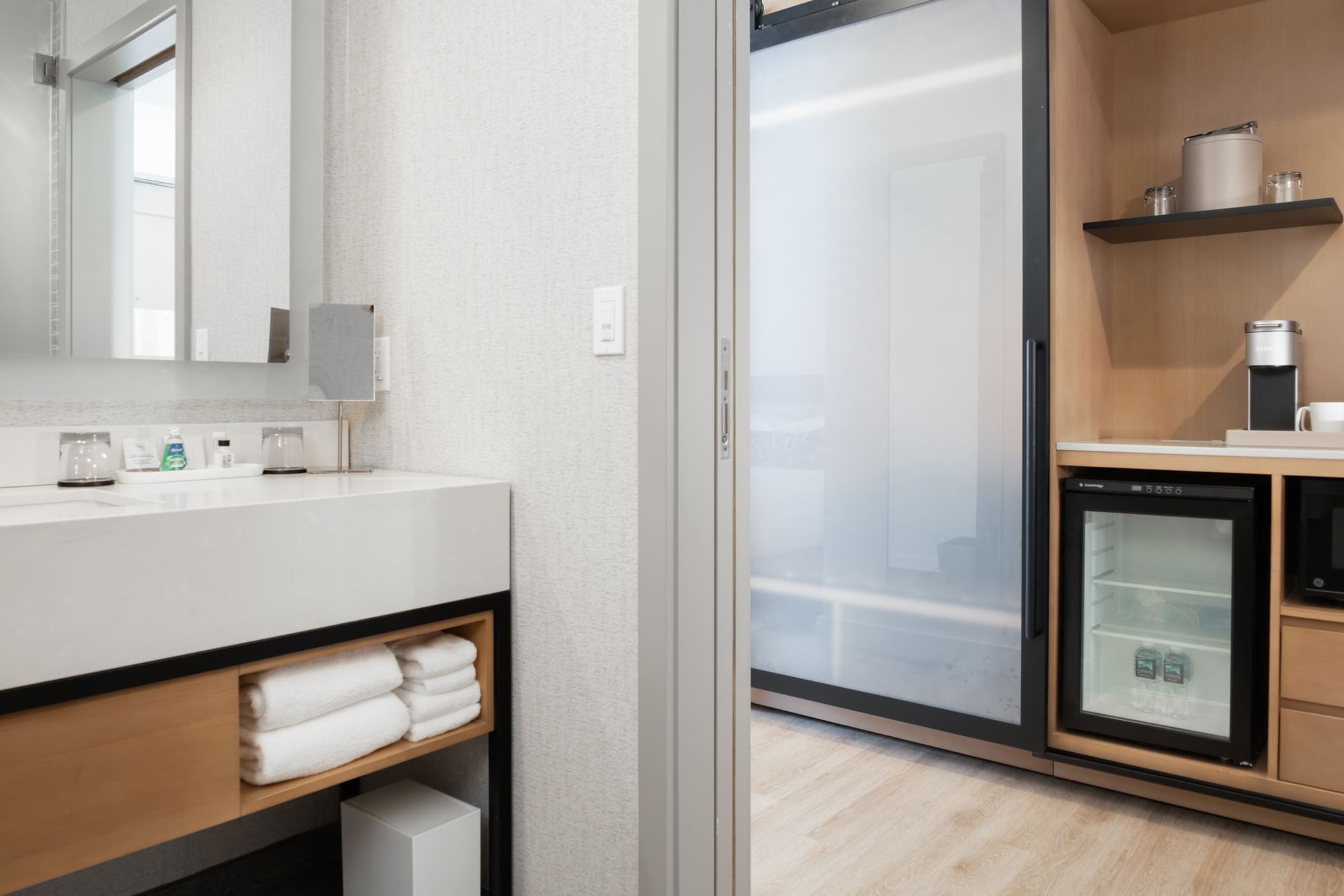A modern bathroom and kitchenette in a hotel room