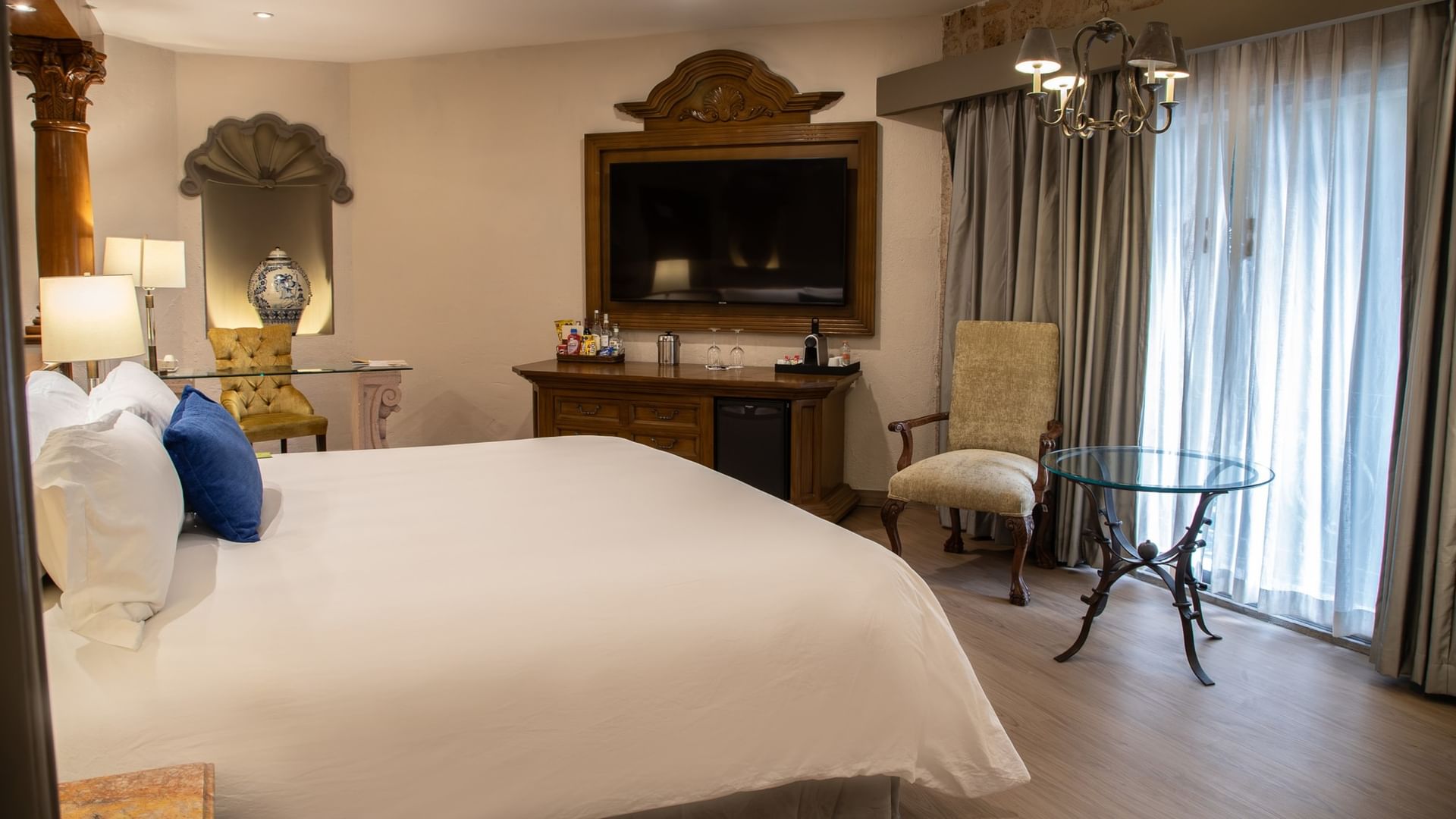 Suite Gran Clase King con cama king, muebles de madera, televisión y mesa de cristal en Quinta Real Guadalajara