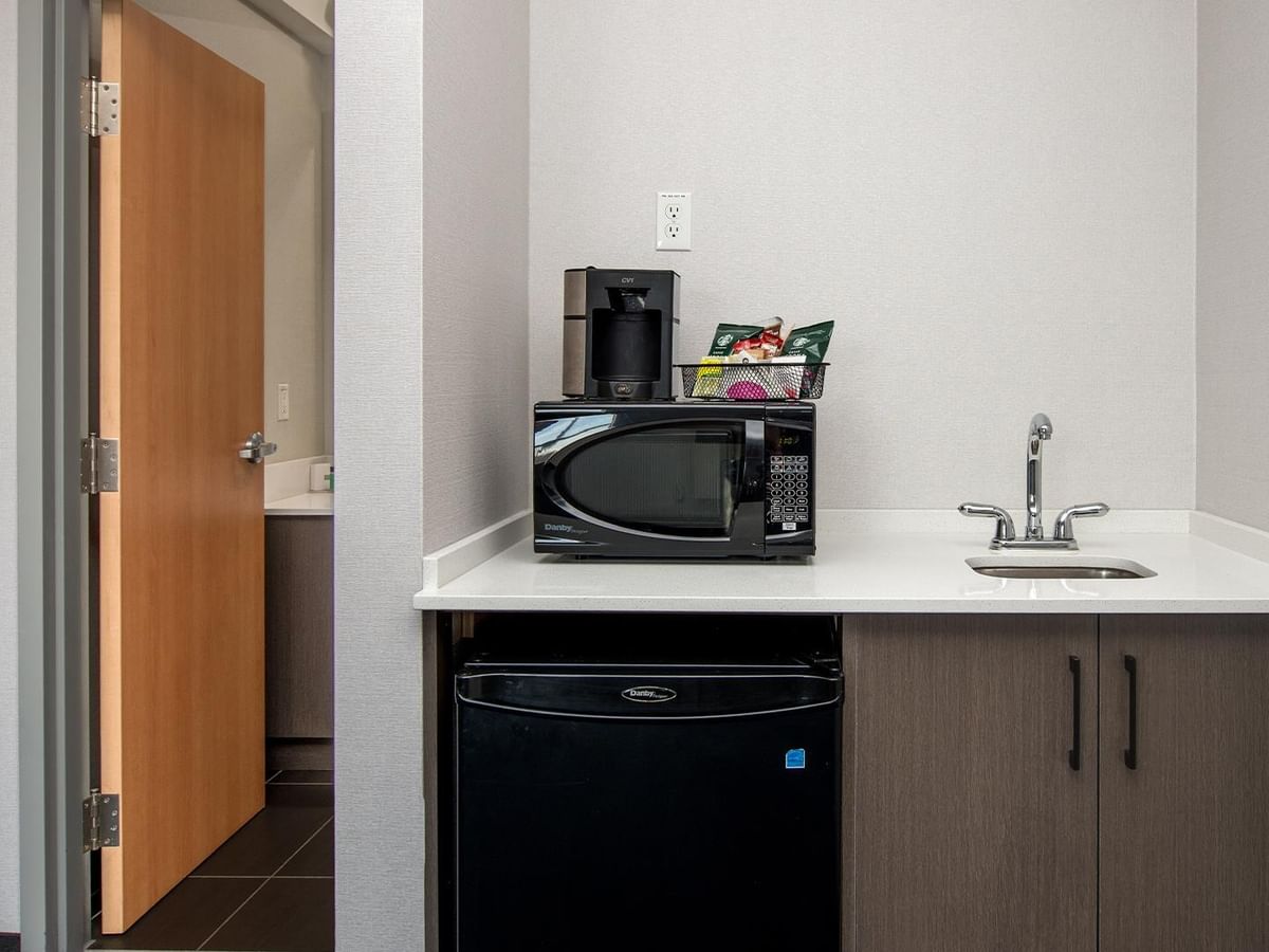 Microwave, coffee maker, sink, and mini fridge.