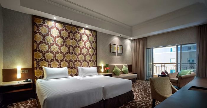 Two beds, sitting area & balcony in junior suite at Sunway Putra Hotel