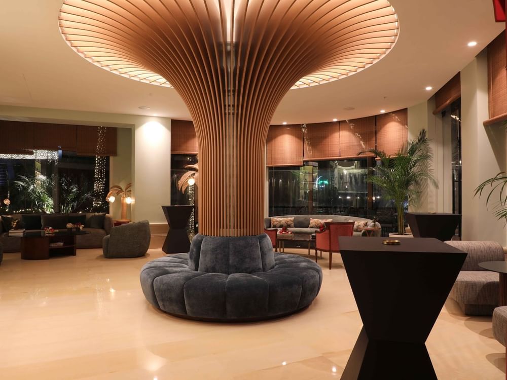 Velvet sofa by a pillar under a fluted wood canopy in the lounge at Warwick Palm Beach Hotel