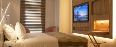 TV and workspace by the cozy bed in the Standard Room at Hotel Nodo, featuring the coziest hotel rooms in Santiago, Chile