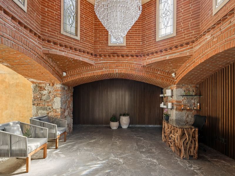 Lobby near Fiesta Americana, featuring a dazzling crystal chandelier, exposed brick arches, and a unique reception desk