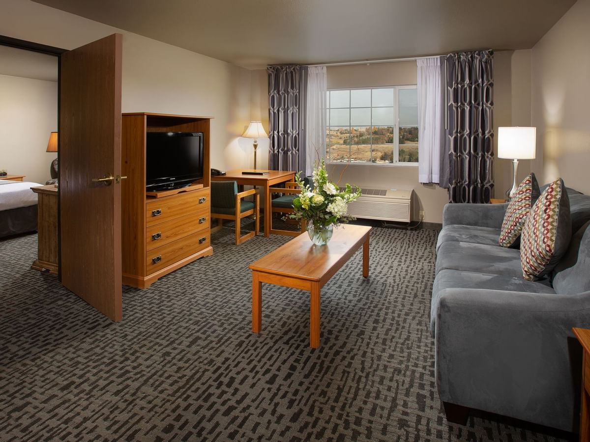 Sofa and living area of hotel suite with entrance to bedroom