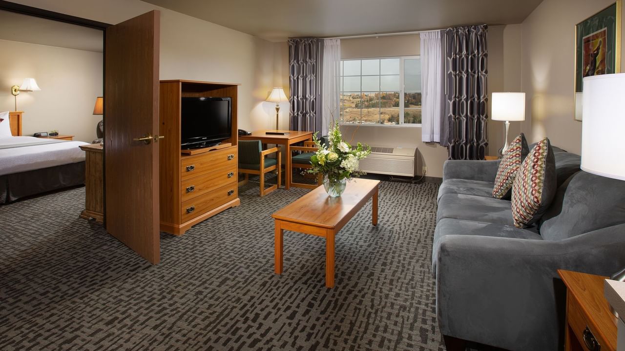 Sofa and living area of hotel suite with entrance to bedroom